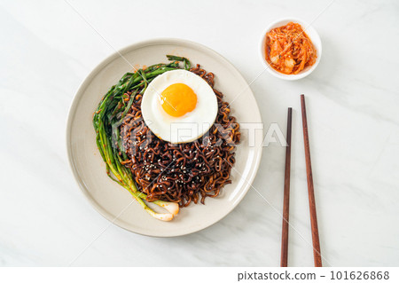 dried Korean spicy black sauce instant noodles with fried egg and kimchi 101626868