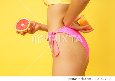 Woman in swimsuit with healthful fresh orange in hand Woman in swimsuit with healthful fresh orange in hand 101627040