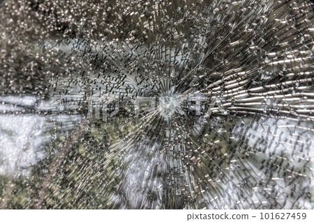 Broken windshield of a car close-up as a background. Texture broken glass with cracks. Broken windshield of a car close-up as a background. Texture broken glass with cracks. 101627459