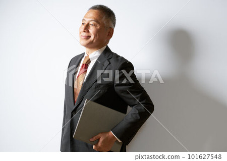 Business image of a senior man holding a laptop under his arm 101627548