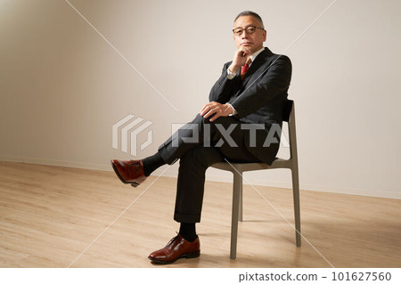 Senior man sitting on a chair and looking Senior man sitting on a chair and looking 101627560
