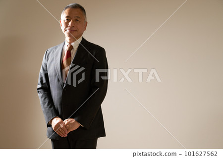一位身穿西裝的資深商人挺直腰板站著 101627562