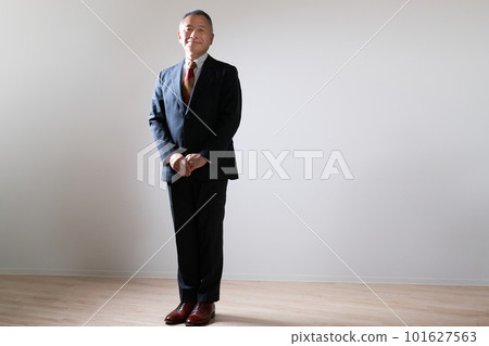 A senior businessman in a suit standing with his back straight 101627563