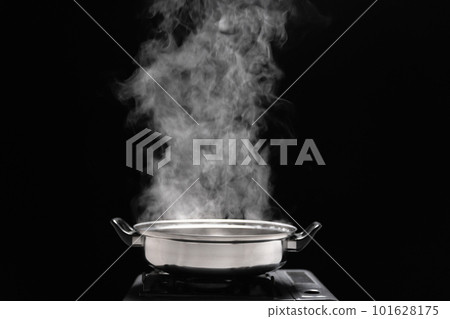 Steam over cooking pot in kitchen on dark background. Steam over cooking pot in kitchen on dark background. 101628175