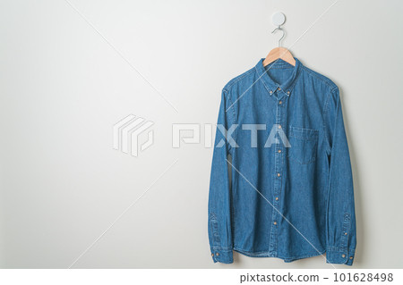 hanging shirt with wood hanger on wall 101628498