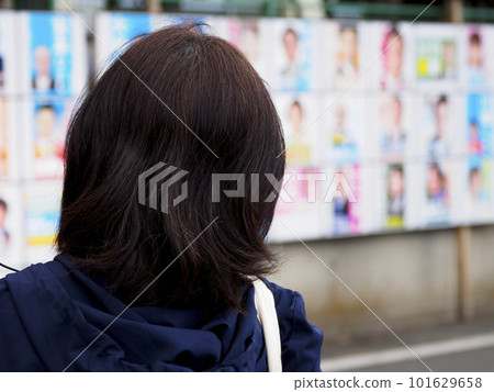 一位女士正在看選舉海報 101629658