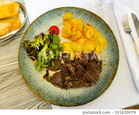 Pork fillet in homemade marinade with fried potatoes and green salad Pork fillet in homemade marinade with fried potatoes and green salad 101630079