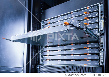 Slot for the hard drives is sticking out in the server room. Computer equipment of the Internet provider is in the data center. Hosting site with a large database. 101630123