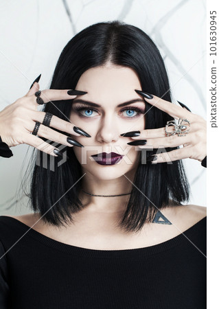 Portrait of beautiful brunette woman with black nails, halloween character 101630945