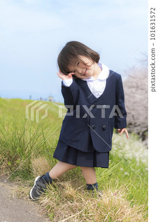 一個穿著幼兒園制服和盛開的櫻花的小女孩 101631572