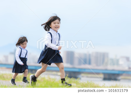 穿幼兒園服的姐妹們在春天的河床上奔跑 101631579