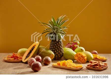 Table with decorations for Chinese New Year celebration in room is five - fruit tray and jam. Dragon fruit, pineapple, mango, papaya, passion fruit on wooden table. Traditional lunar new yea 101631996