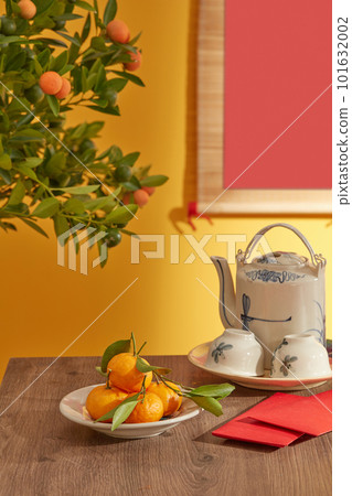 Chinese new year festival table with tea set, fruits and lucky money. Table with beautiful decorations for Chinese New Year celebration in room. Front view. Lunar new year. 101632002