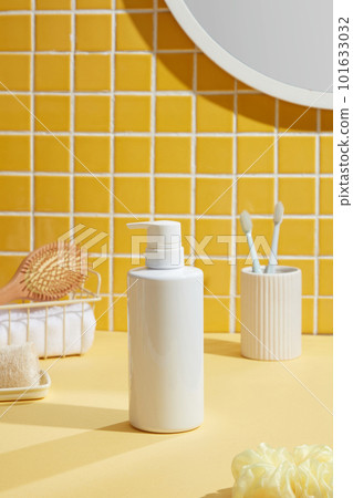 Many white items and a bottle with no label over a simple and spotless bathroom background. A mirror on the wall 101633032