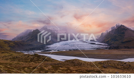 Glacier tongue slides from the Vatnajokull icecap or Vatna Glacier near subglacial Oraefajokull volcano, Iceland. Glacial lagoon with ice blocks and surrounding mountains. 101633610