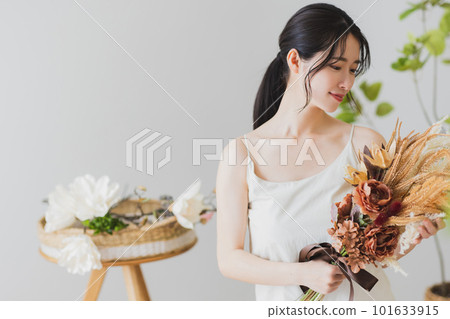 A woman making a bouquet of dried flowers 101633915
