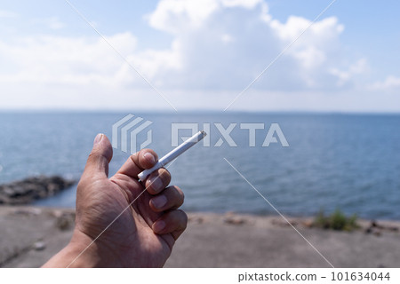 男人的手在沙灘上抽著煙 101634044
