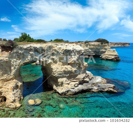 Picturesque seascape with cliffs, rocky arch and stacks (faraglioni), at Torre Sant Andrea, Salento sea coast, Puglia, Italy 101634282