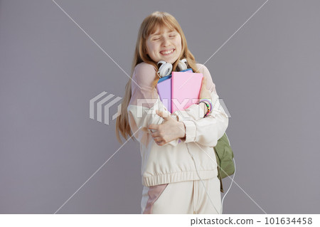 happy trendy pupil in beige tracksuit hugging herself happy trendy pupil in beige tracksuit hugging herself 101634458