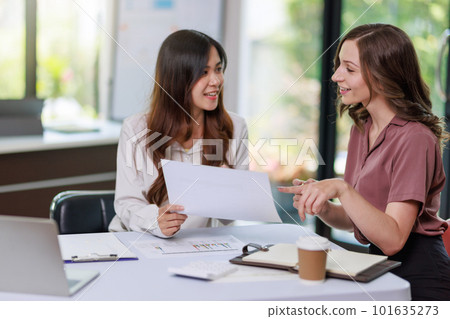 Concept of business office woman working,Businesswoman smile while working about her invesment plan with analyzing document and business investment graph data by using laptop on desk in workstation. 101635273
