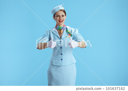 happy modern female stewardess on blue showing thumbs up 101637182
