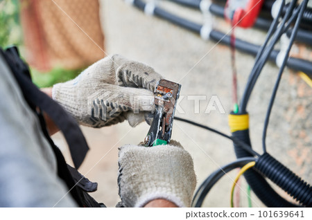 Man electrician installing solar panel system. Close up technician hands in gloves making electrical wiring inverter and electric box. Concept of alternative and renewable energy. Man electrician installing solar panel system. Close up technician hands in gloves making electrical wiring inverter and electric box. Concept of alternative and renewable energy. 101639641