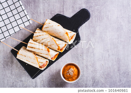 Homemade corn dogs in grilled tortilla with sauce on slate on the table top view 101640981