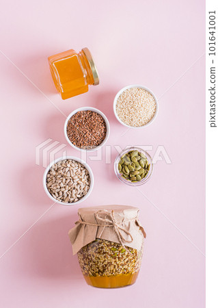 Healthy mixture of honey and various seeds in a jar and ingredients for cooking top and vertical view Healthy mixture of honey and various seeds in a jar and ingredients for cooking top and vertical view 101641001