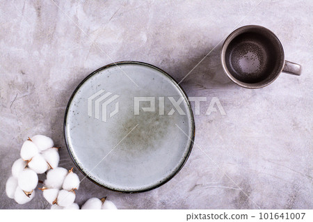 Mockup of empty ceramic plate, cup and cotton branch on gray background top view Mockup of empty ceramic plate, cup and cotton branch on gray background top view 101641007