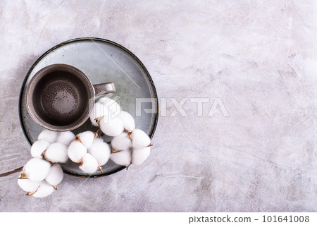 Empty ceramic mug and branch in cotton on a plate on a gray background top view Empty ceramic mug and branch in cotton on a plate on a gray background top view 101641008