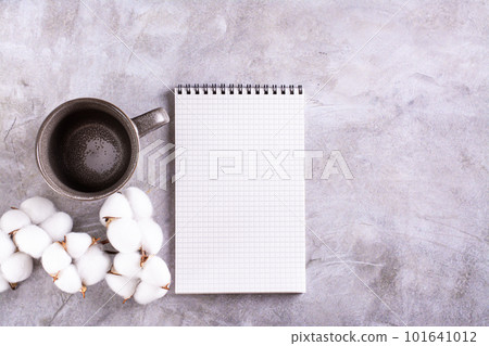 Mockup of a blank open notebook, an empty mug and a branch of cotton on a gray background top view Mockup of a blank open notebook, an empty mug and a branch of cotton on a gray background top view 101641012