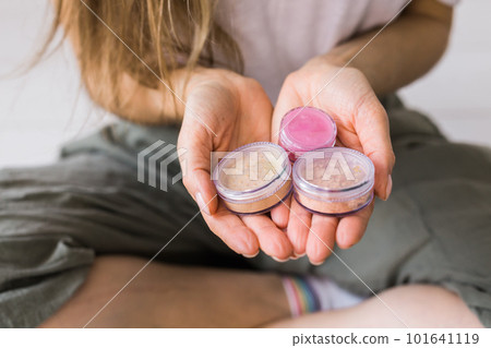 Close-up woman keeps makeup mineral powder for face and eyeshadows - make-up products and eco mineral natural cosmetic Close-up woman keeps makeup mineral powder for face and eyeshadows - make-up products and eco mineral natural cosmetic 101641119