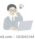 A man in a suit who worries while operating a computer 101642144