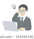 A man in a suit who worries while operating a computer 101642146