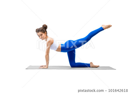 Caucasian young beautiful smiling woman does leg kicks on a mat standing on all fours, isolated on white. 101642618