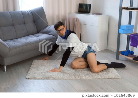 Funny man in glasses with weight on neck is doing push-ups exercise at home. Funny man in glasses with weight on neck is doing push-ups exercise at home. 101643869