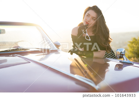 beautiful girl in retro style posing near vintage red cabriolet car. 101643933