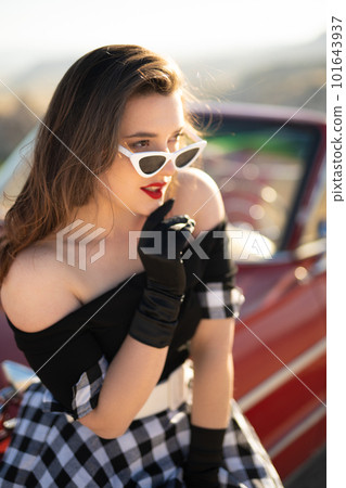 beautiful girl in retro style posing near vintage red cabriolet car. beautiful girl in retro style posing near vintage red cabriolet car. 101643937