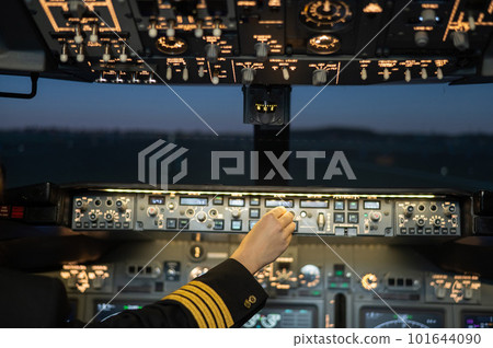 Close-up of a pilot's hand on an airplane control panel. 101644090