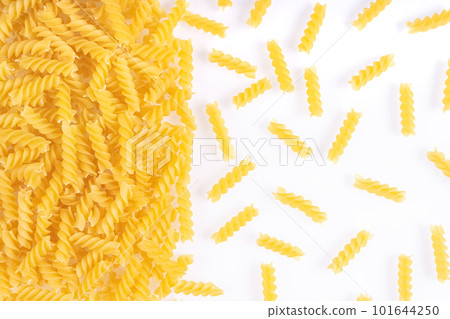 Scattered raw pasta fusilli isolated on white background. Food background, italian cuisine Scattered raw pasta fusilli isolated on white background. Food background, italian cuisine 101644250