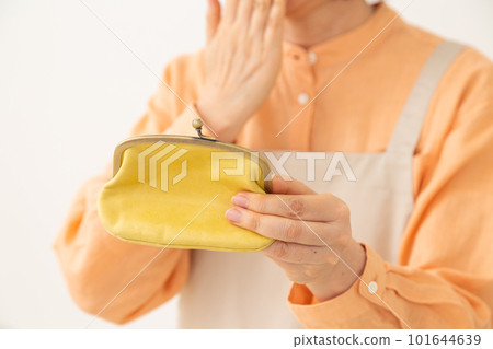 A senior woman in an apron who is worried about holding a wallet A senior woman in an apron who is worried about holding a wallet 101644639