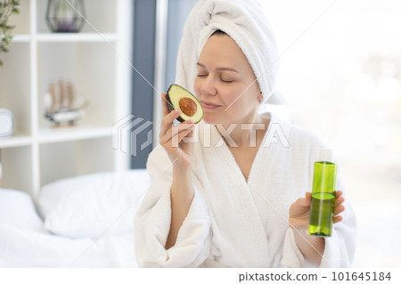 Woman enjoying avocado facial oil during at-home spa day Woman enjoying avocado facial oil during at-home spa day 101645184