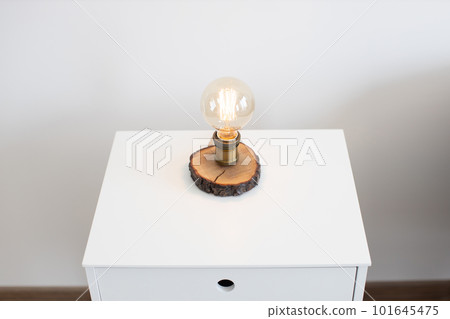 Edison lamp on bedside table near sofa in studio room 101645475