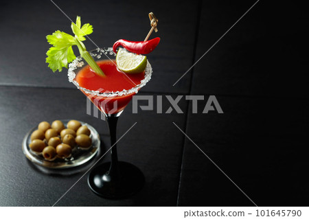 Bloody Mary cocktail with celery, lime, red pepper, and green olives. 101645790