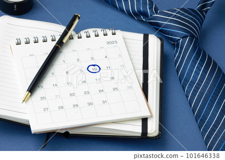 Pen on calendar with marked date and tie on table Pen on calendar with marked date and tie on table 101646338