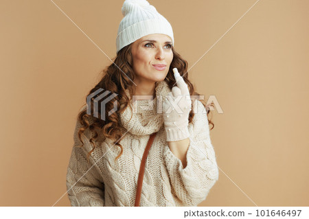 modern 40 years old woman in beige sweater, mittens and hat 101646497