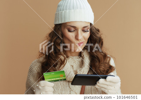 pensive stylish woman with smartphone buying online 101646501