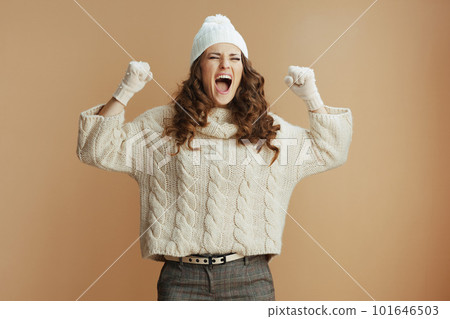 smiling stylish woman rejoicing on beige background 101646503