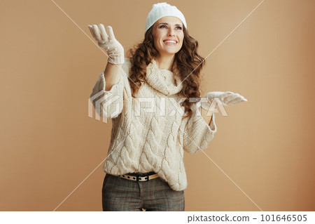 happy elegant woman isolated on beige background catching snow happy elegant woman isolated on beige background catching snow 101646505