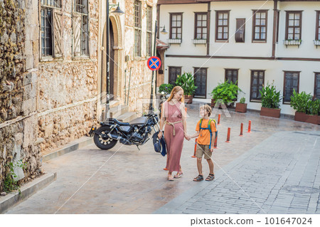 Mom and son tourists in Old town Kaleici in Antalya. Turkiye. Panoramic view of Antalya Old Town port, Taurus mountains and Mediterrranean Sea, Turkey. Traveling with kids concept 101647024
